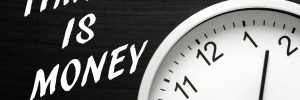 Time Is Money concept with a clock and blackboard