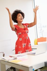 Excited Woman Working At Desk In Design Studio