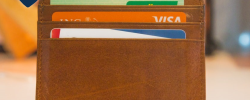 a brown wallet with three credit cards inside