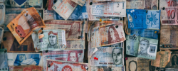 a wall with many countries’ banknotes pinned to it