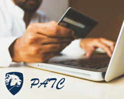 person using a laptop and holding a bank card